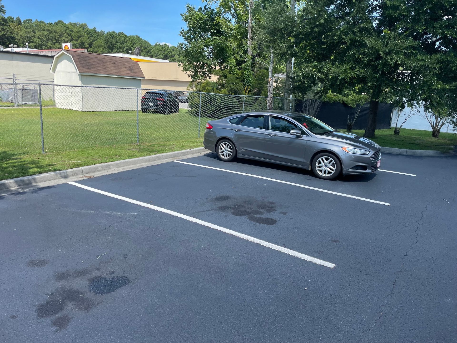 A gray car is parked in a parking lot.