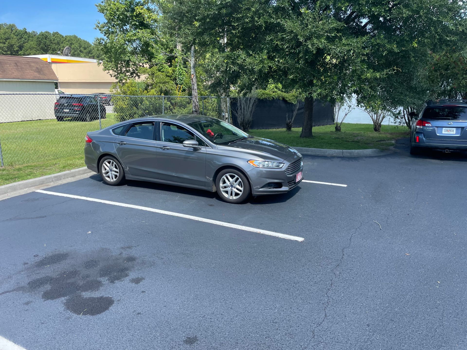 A gray car is parked in a parking lot.