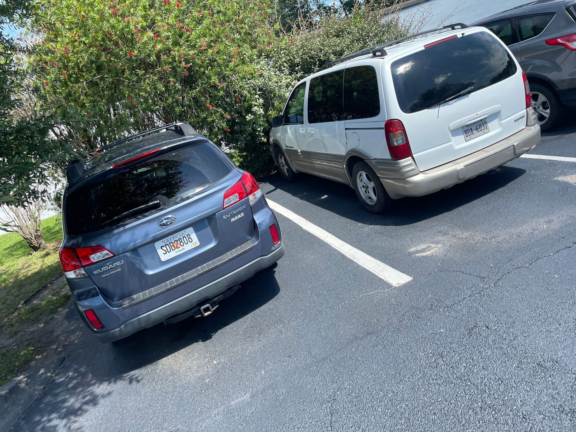 Two cars are parked next to each other in a parking lot.
