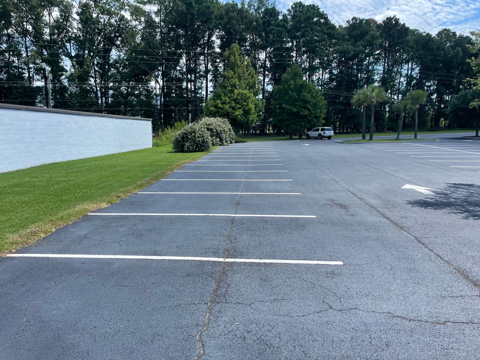 A parking lot with a white arrow pointing to the right