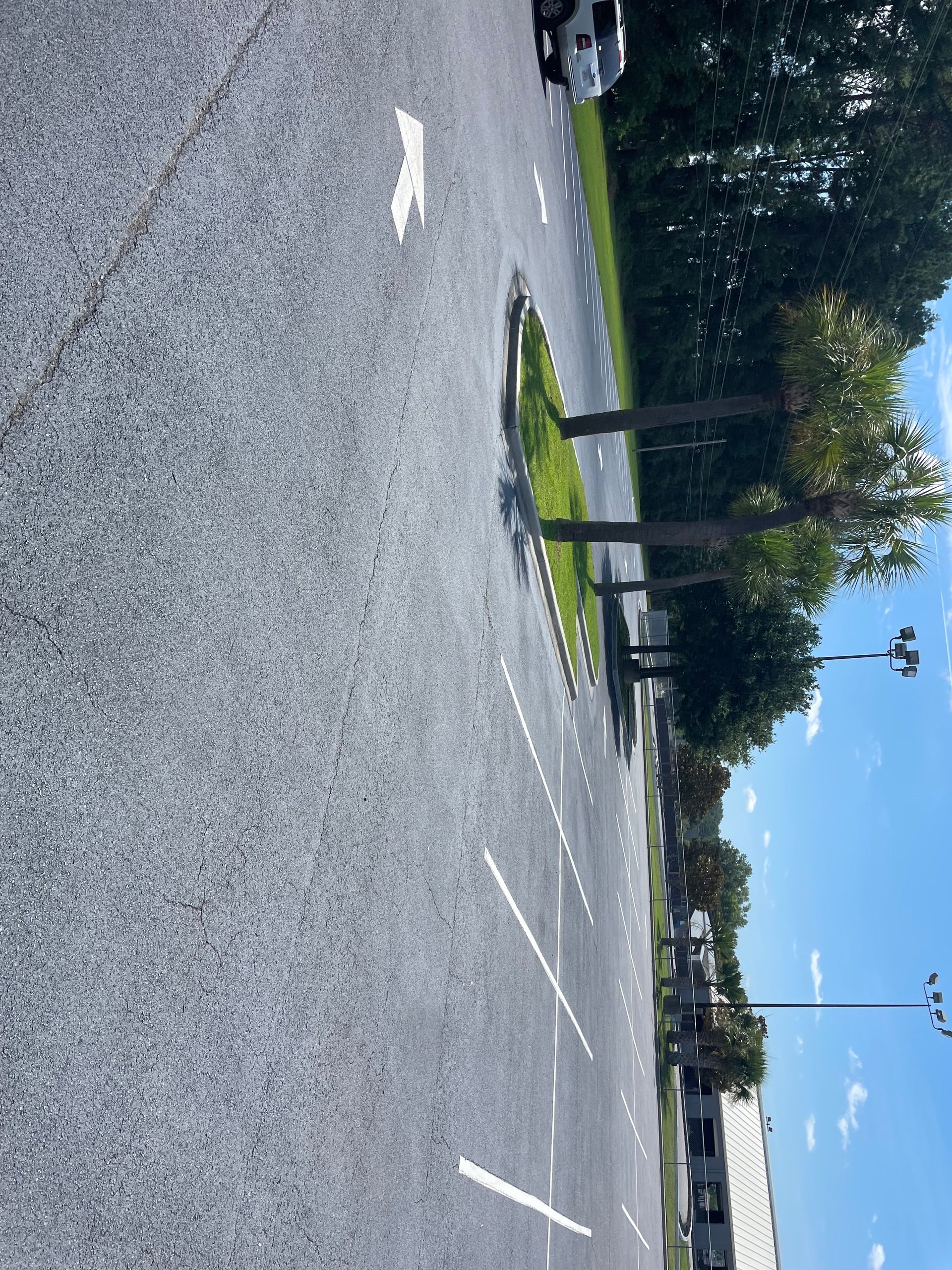 A car is parked on the side of the road in a parking lot.