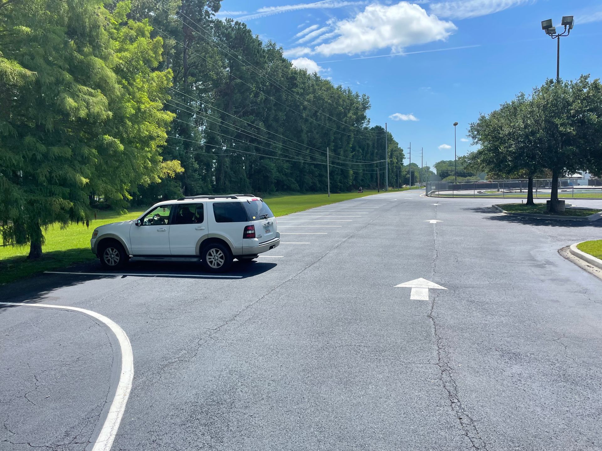 A white suv is parked in a parking lot with an arrow pointing to the right