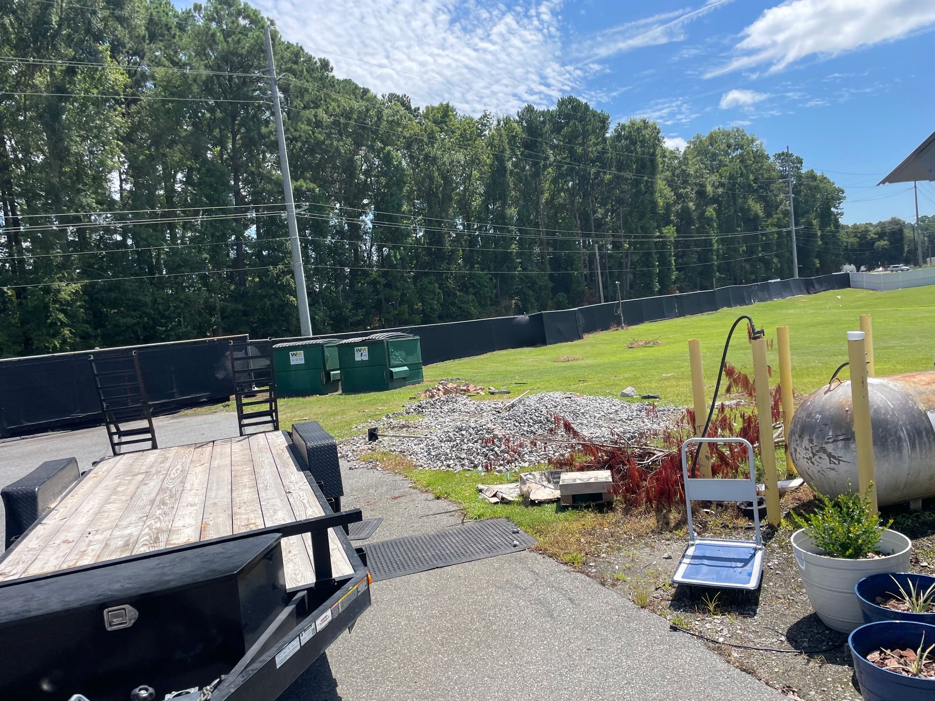 A trailer is parked in front of a grassy field.