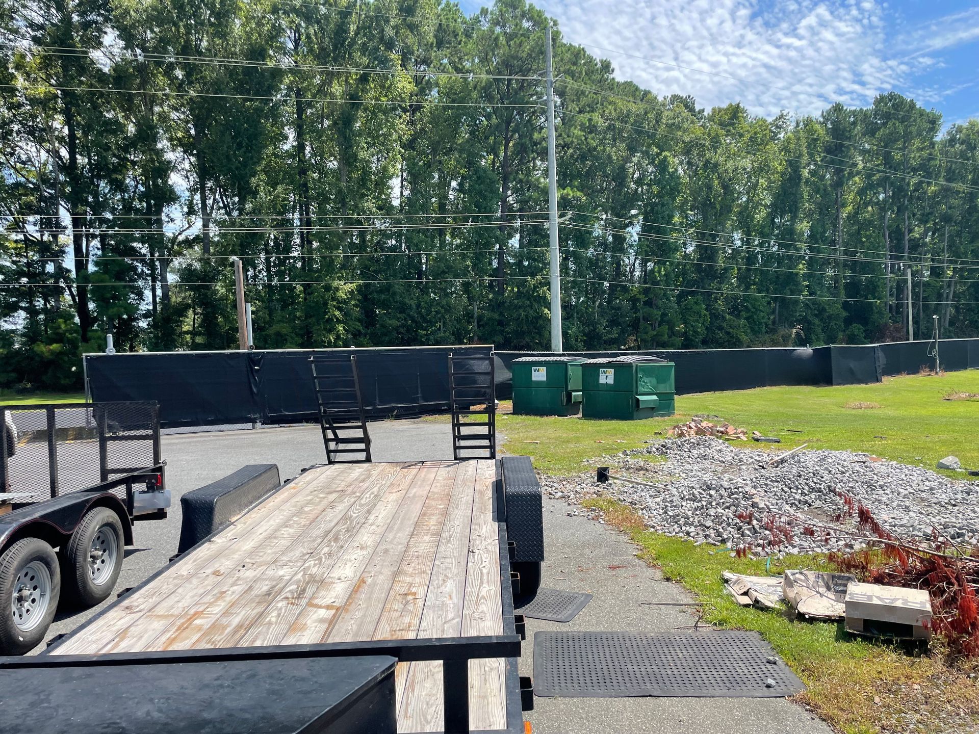 A trailer is parked in a field with trees in the background.