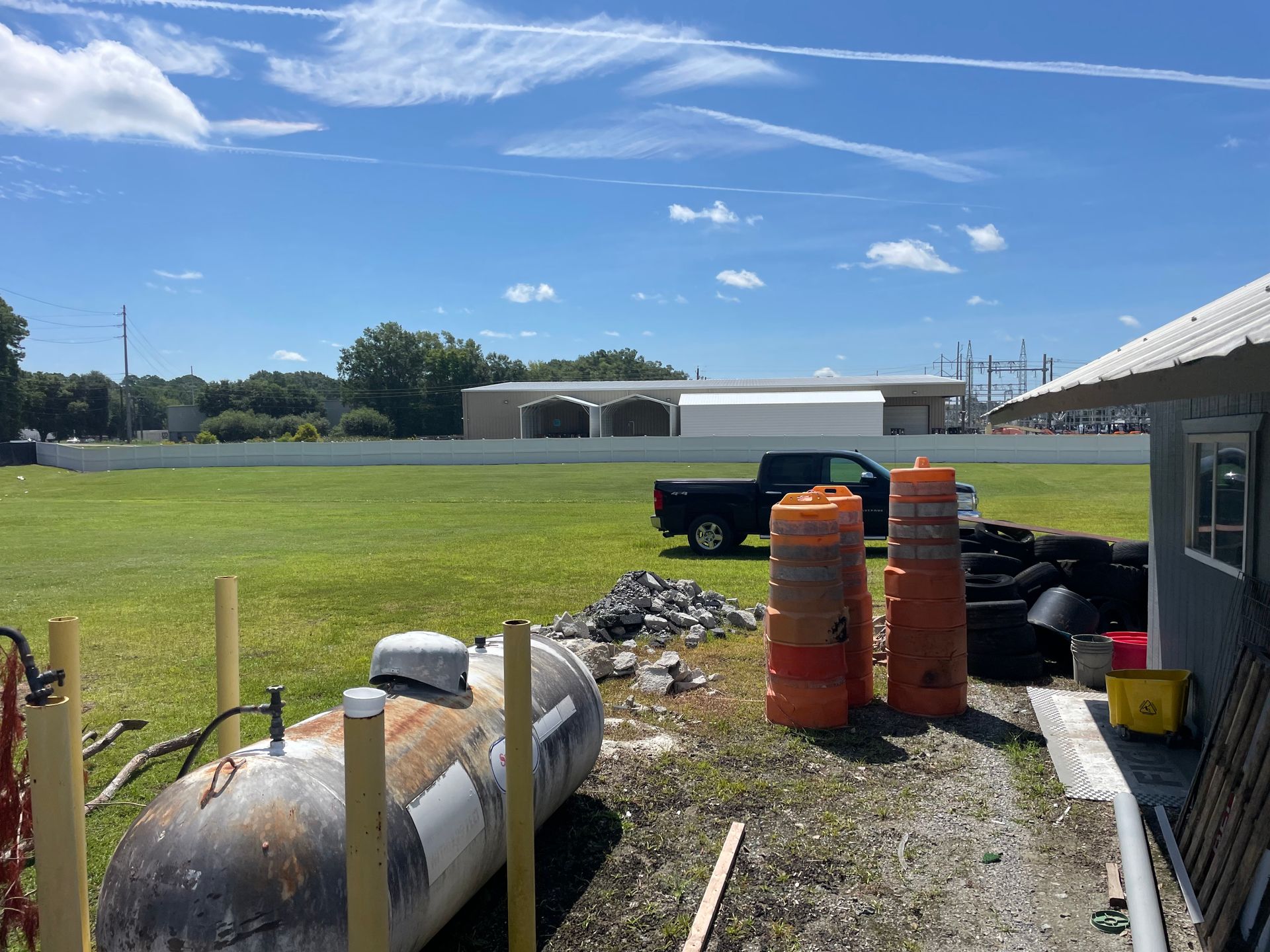 A propane tank is sitting in the middle of a grassy field.