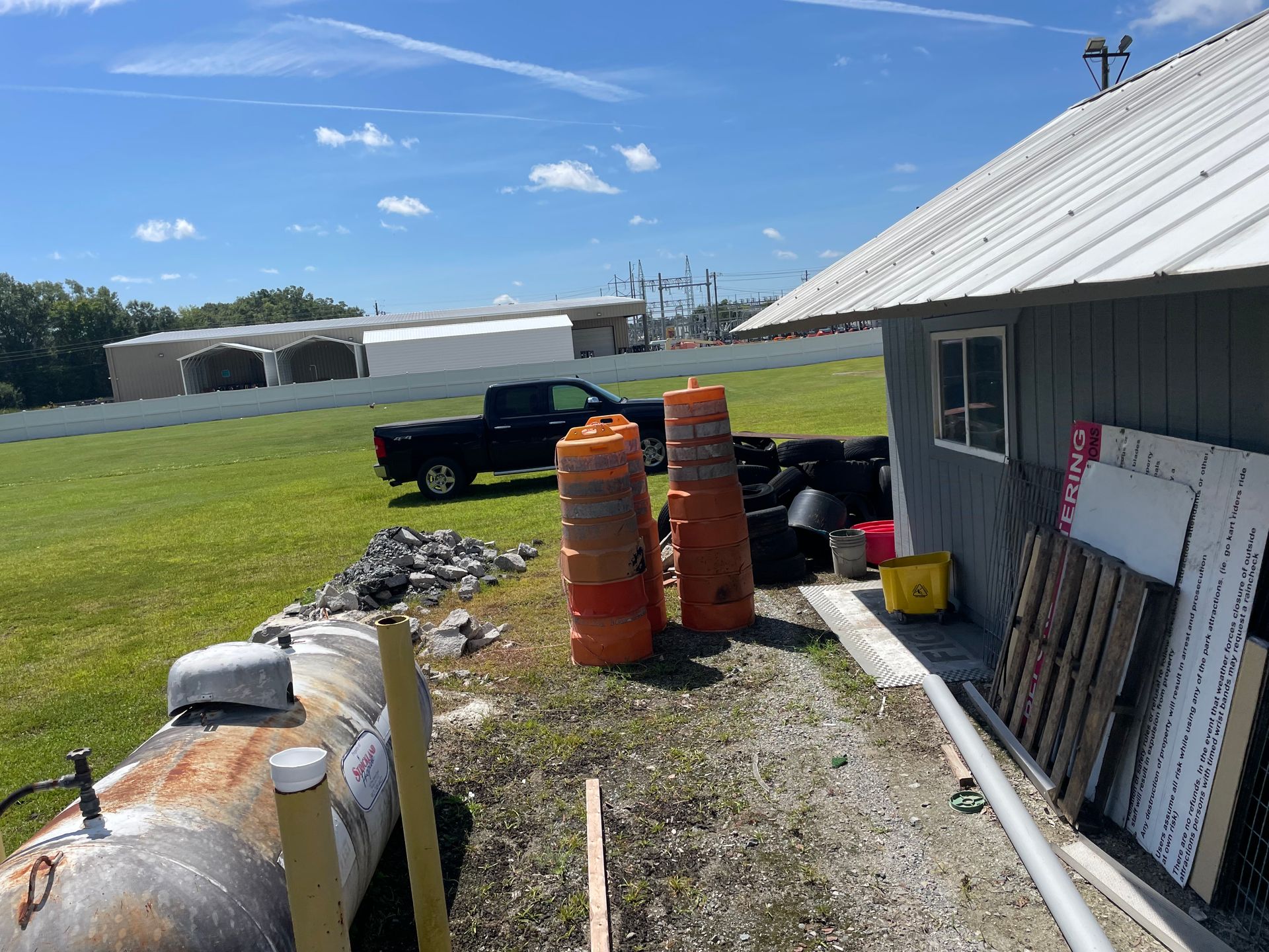A truck is parked in front of a building in a field.