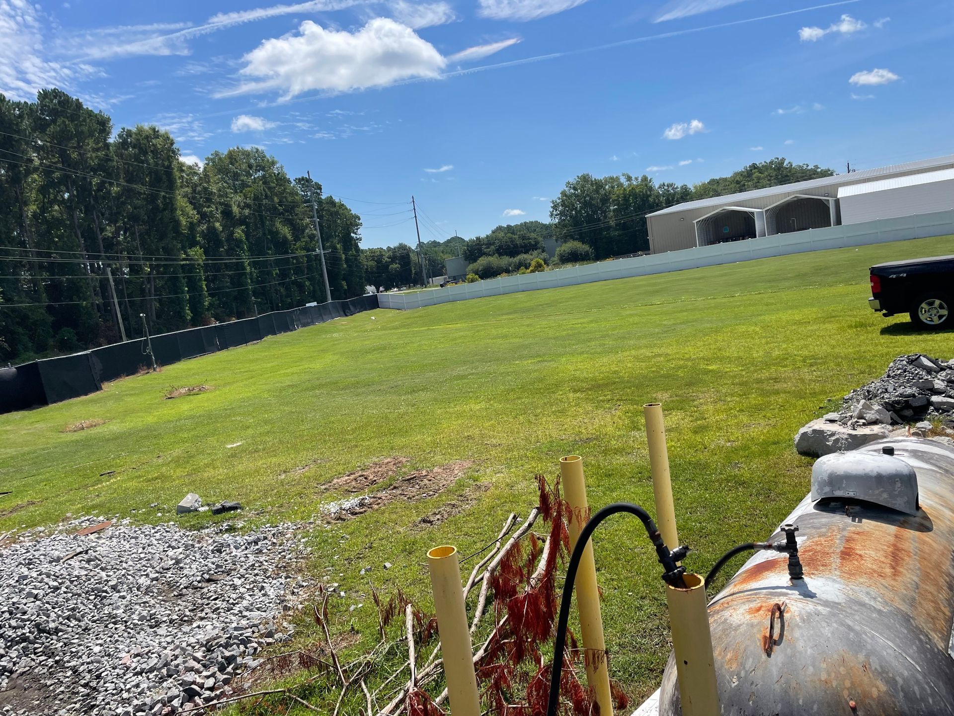 A large grassy field with a truck parked in the background.