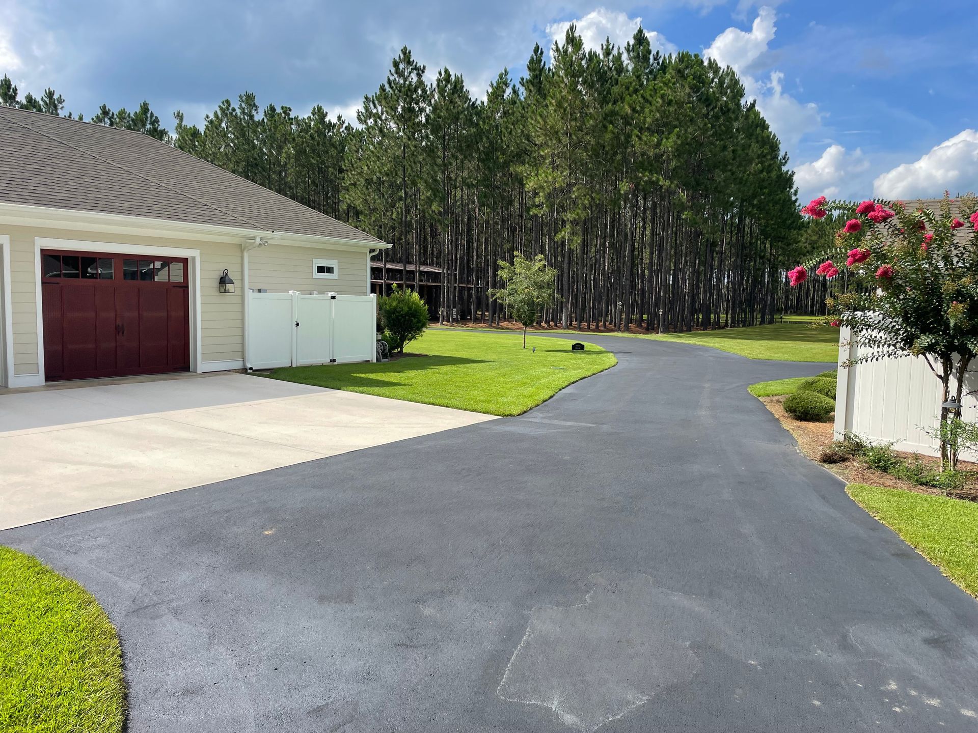 A driveway leading to a house with a red garage door