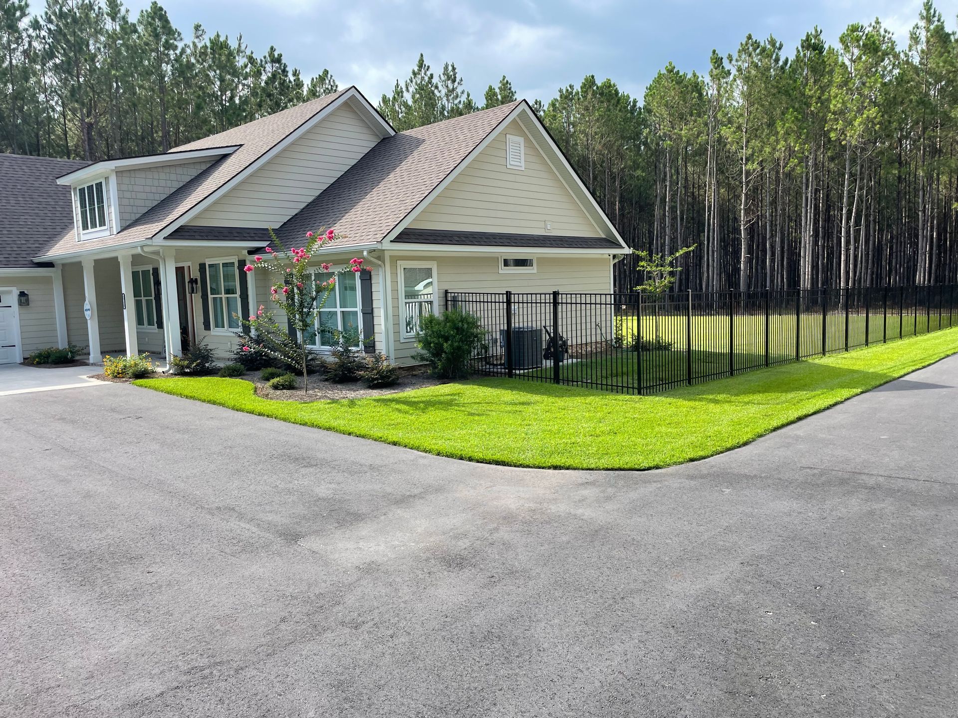 A house with a fence around it and trees in the background
