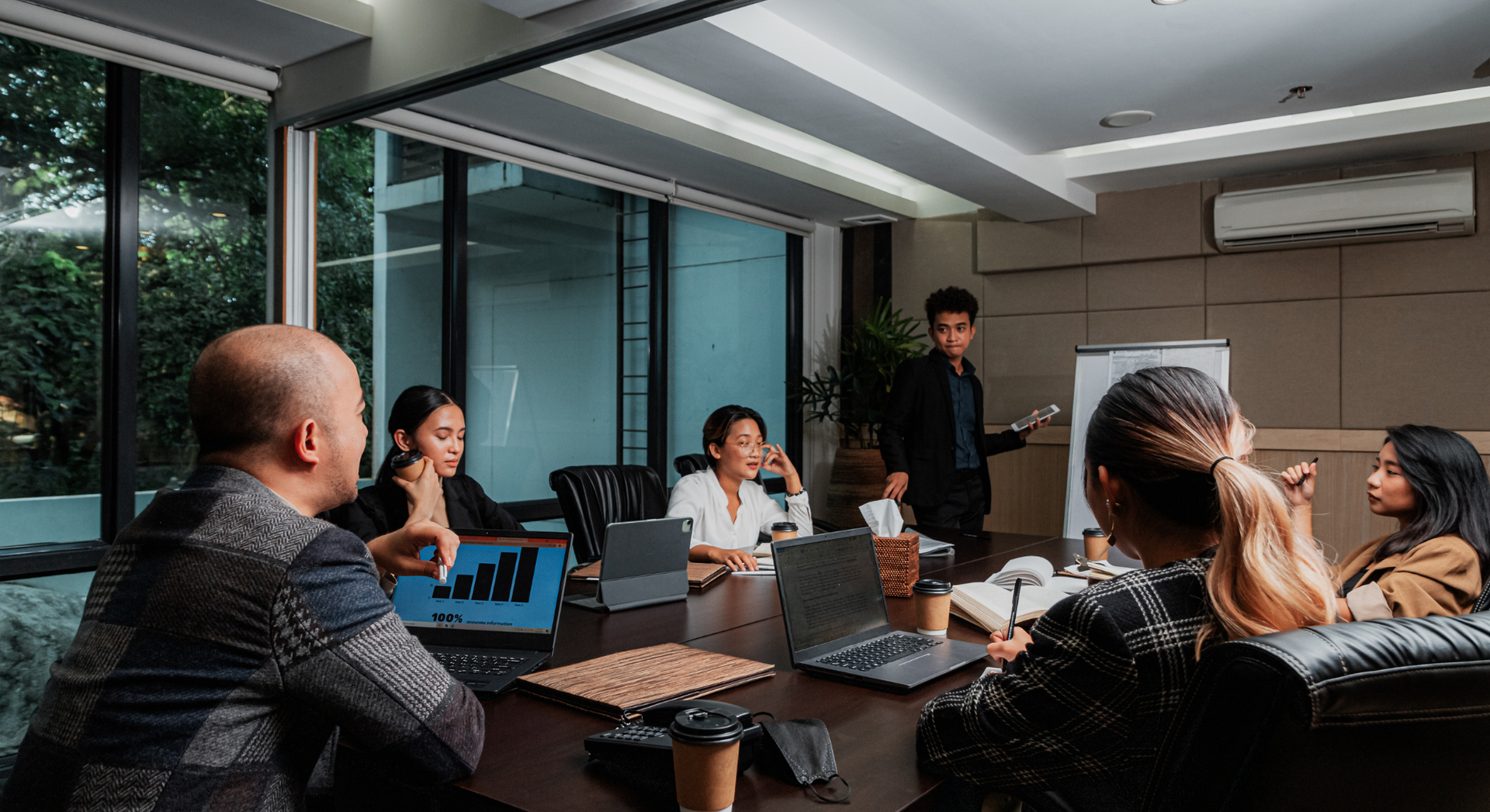 A group of people are sitting around a table in a conference room.