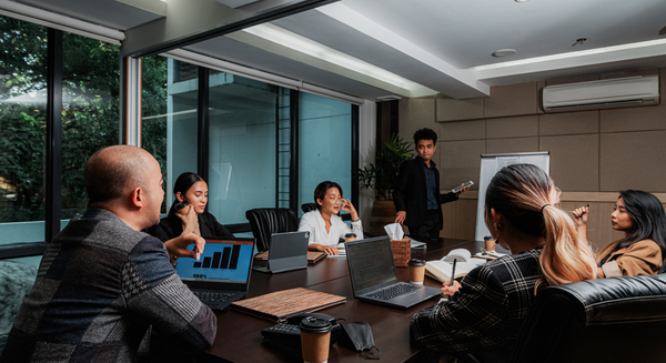 A group of people are sitting around a table in a conference room.