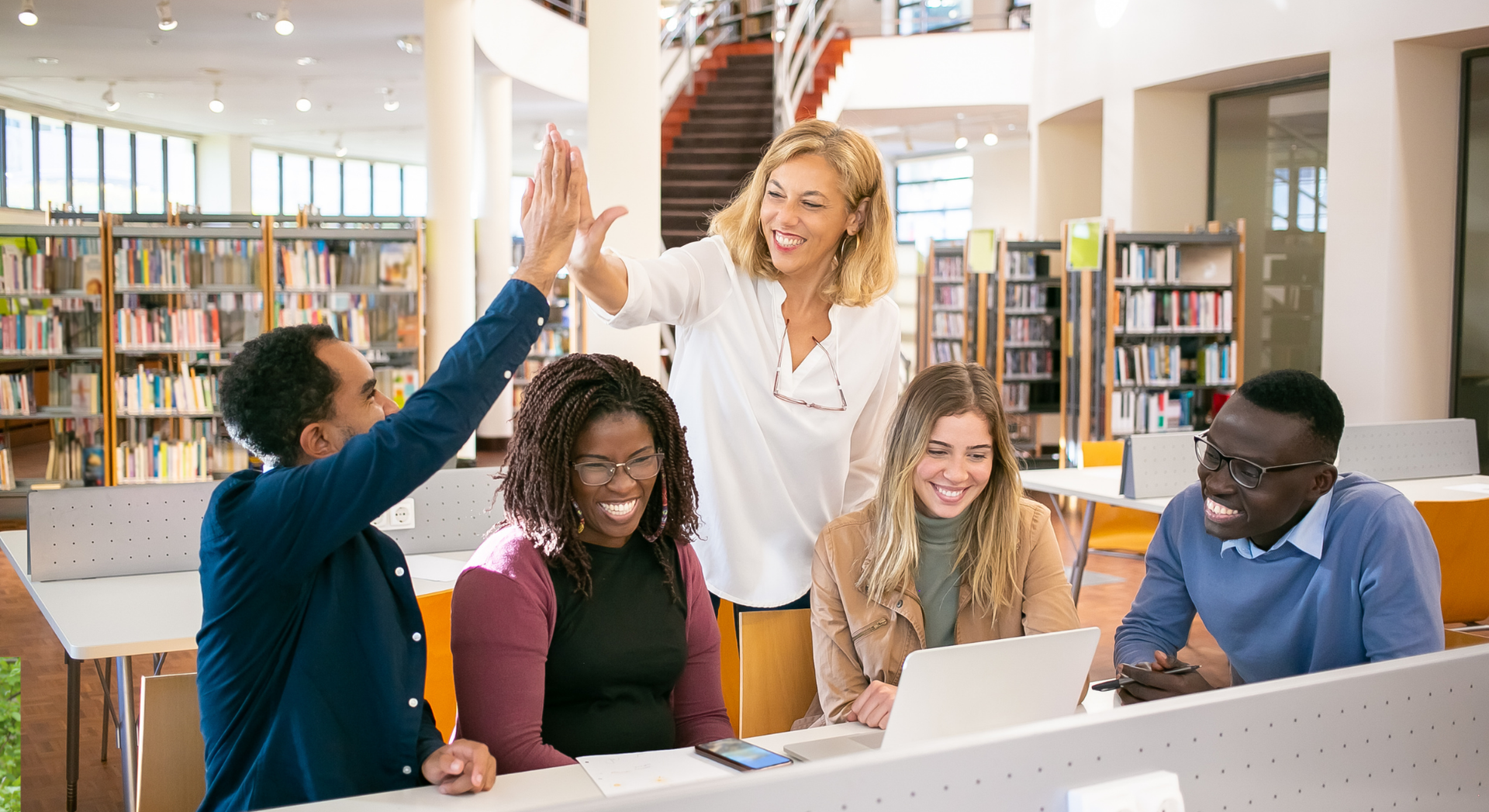 A group of people are giving each other a high five in a library.
