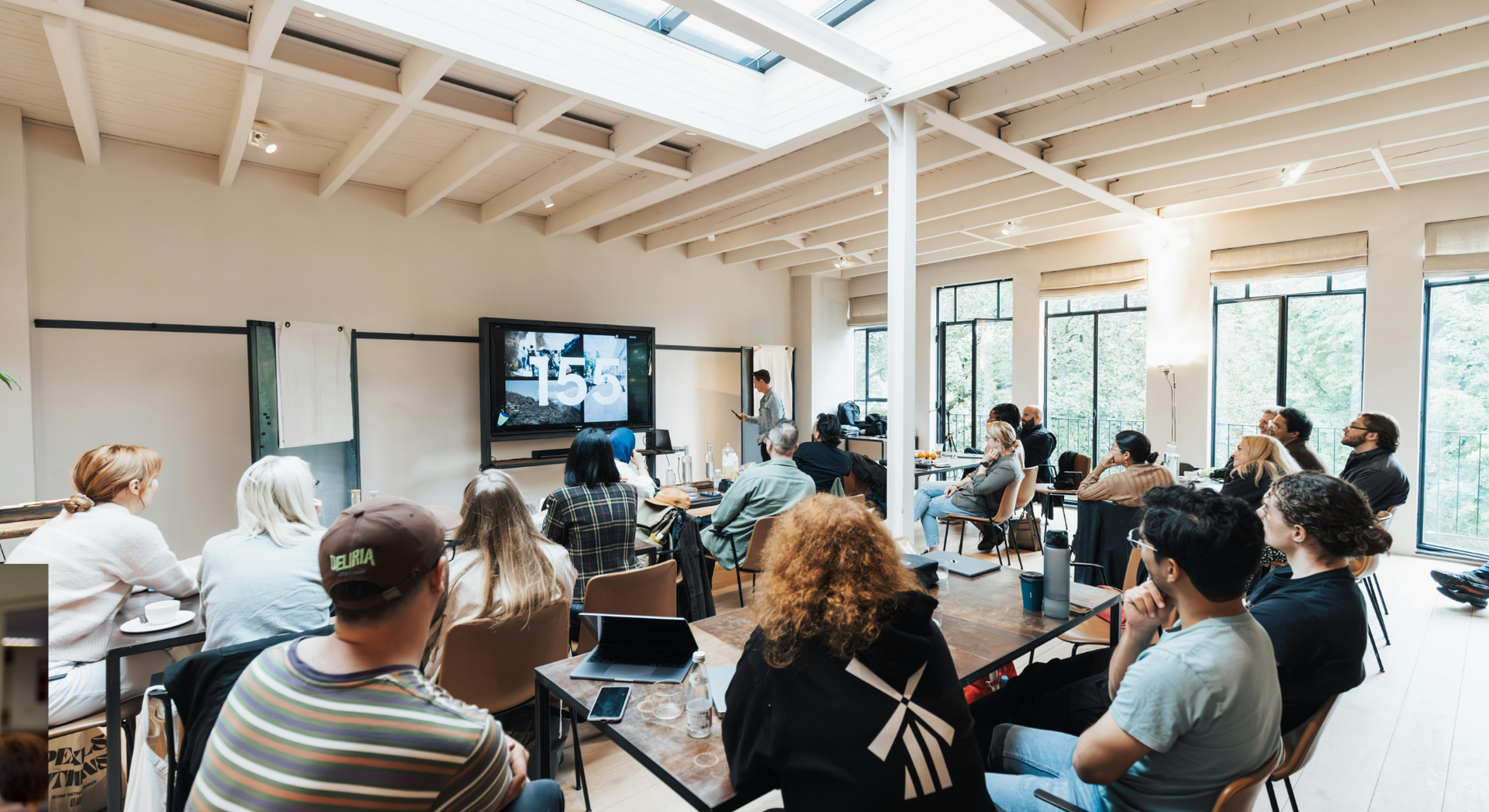 A group of people are sitting in a room watching a presentation.