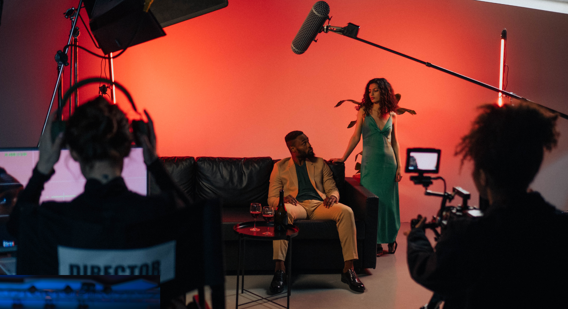 A man and a woman are sitting on a couch in front of a camera.