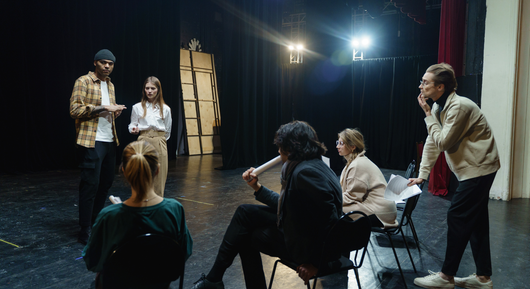 A group of people are sitting in chairs on a stage.