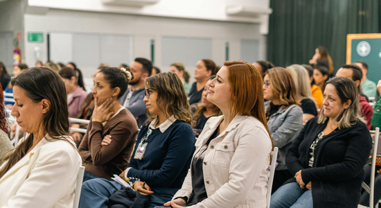 A group of people are sitting in a room watching a presentation.