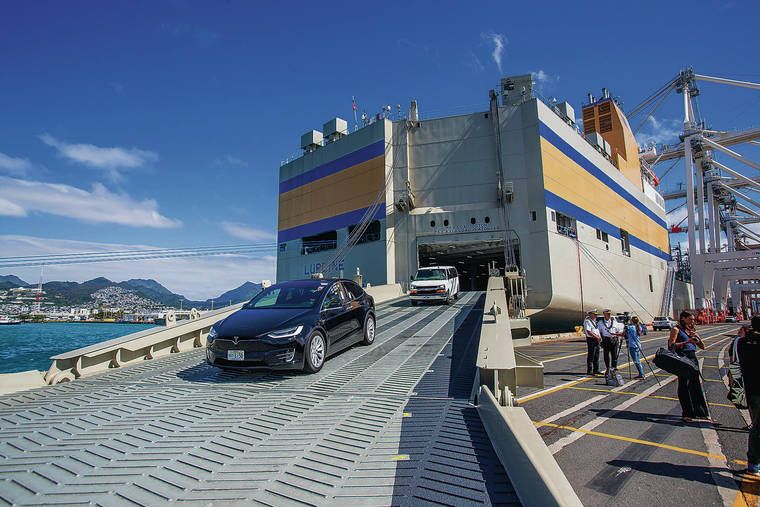 Ocean freight carrier vessel loading cars and trucks for vehicle transport staging at a mainland shipping port to Hawaii