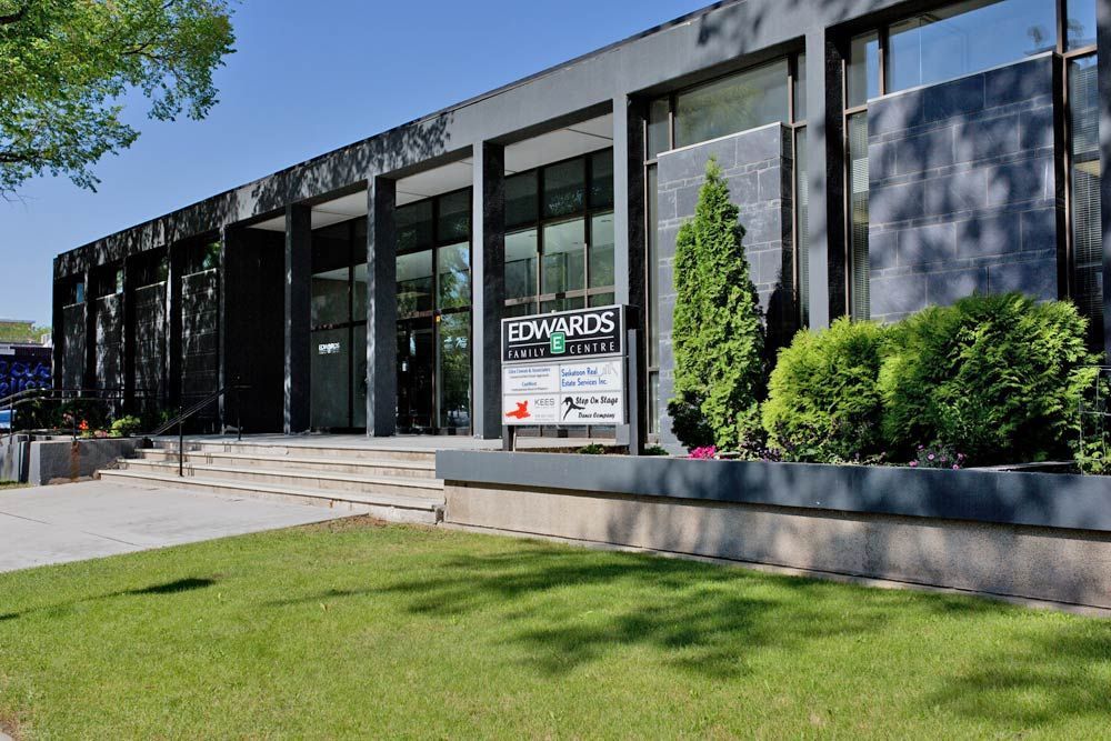 A large building with a lot of windows and a sign in front of it.