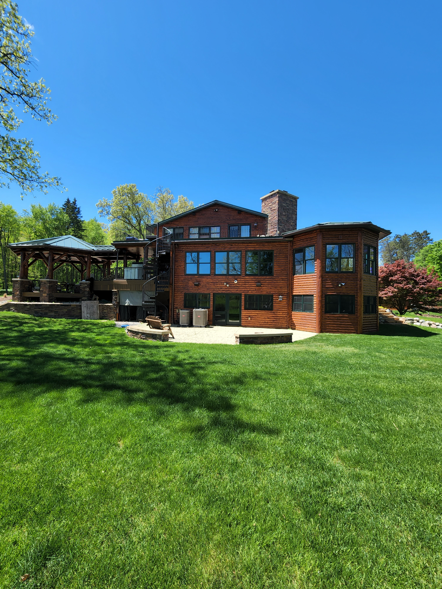 A large brick house is sitting on top of a lush green hillside.