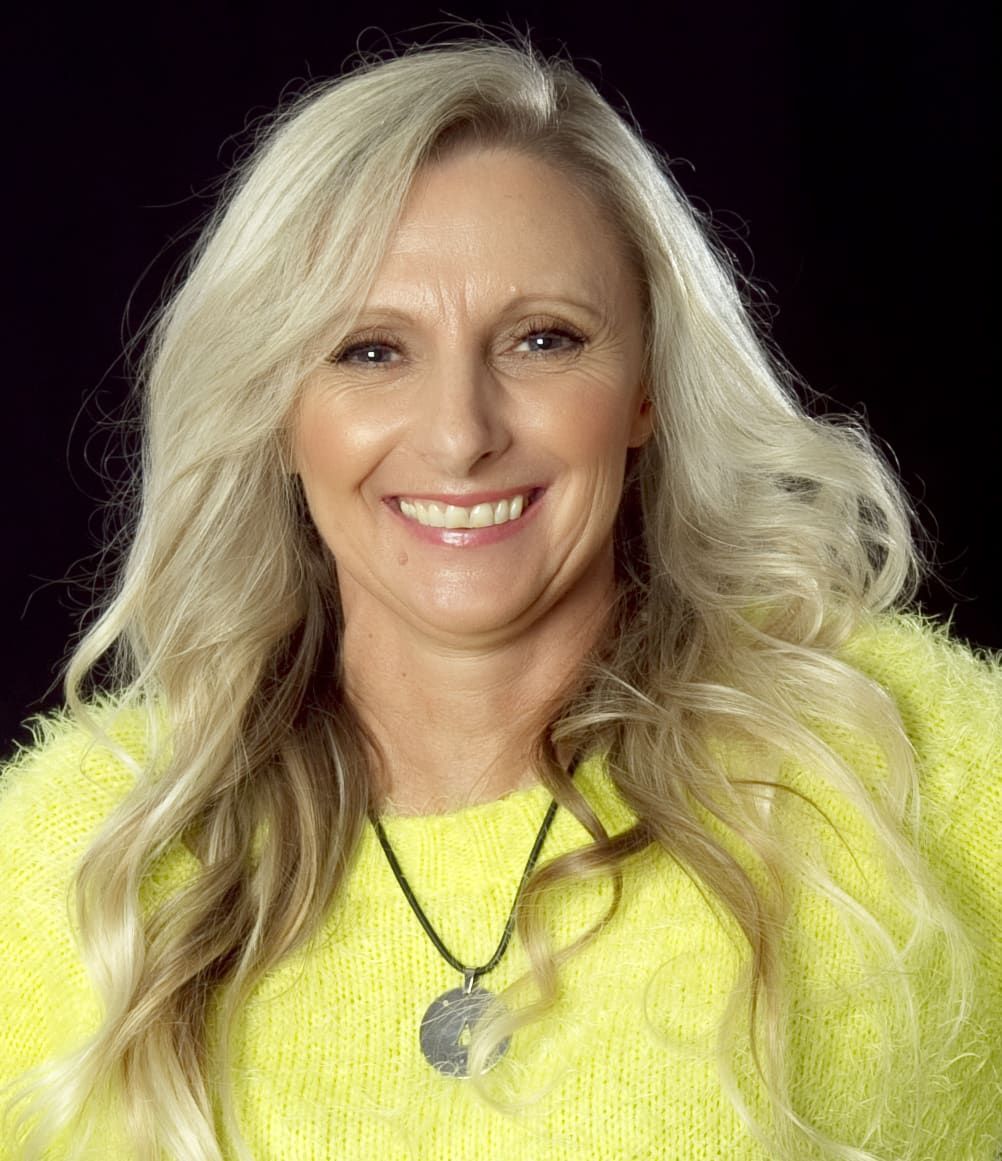 A Woman Wearing A Yellow Sweater And A Necklace Is Smiling — My Energetic Craft In Morisset, NSW