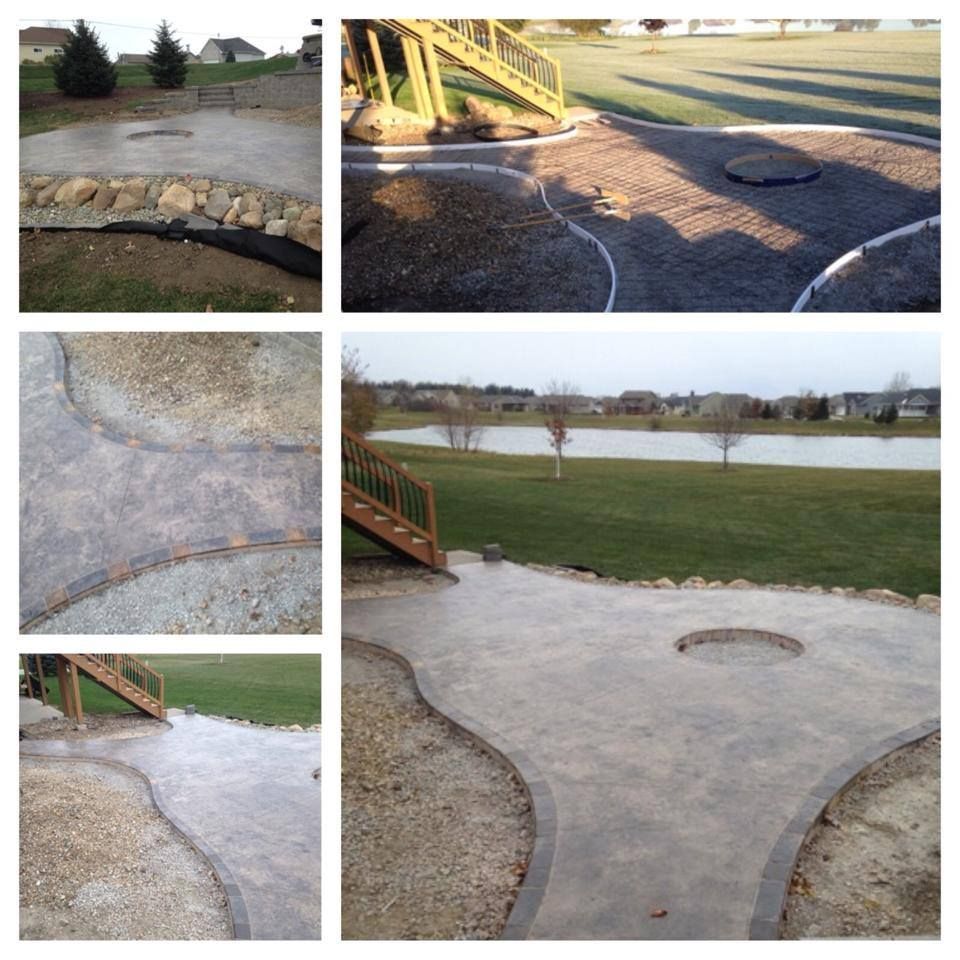 Concrete patio with curved gravel borders, a fire pit, and a view of a lake.