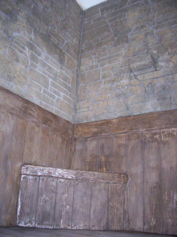 Stone walled corner with wooden paneling and a small ledge.