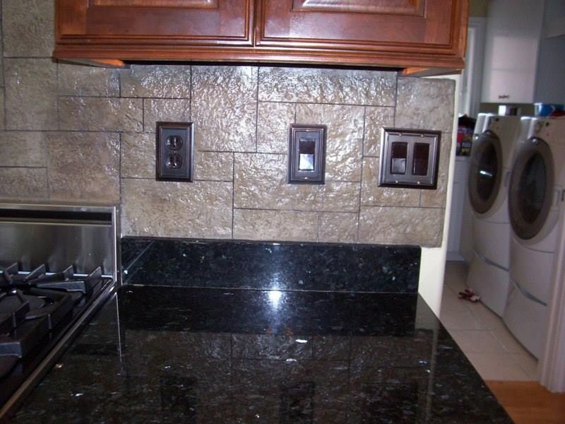 Kitchen backsplash with electrical outlets, granite countertop, and stove.