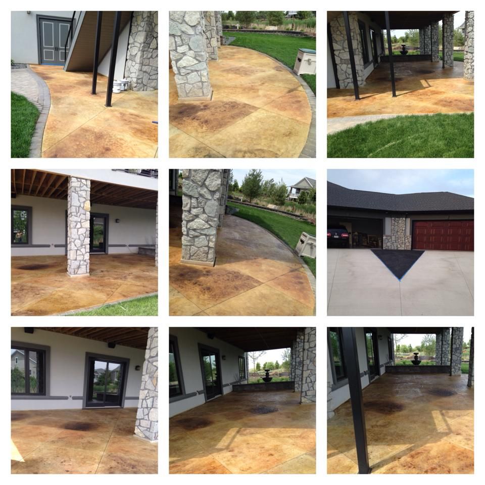 Stamped concrete patios with stone columns and a hint of green lawn.