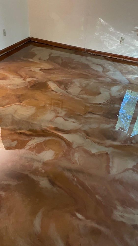 Metallic epoxy floor with swirling gold, brown, and white tones.