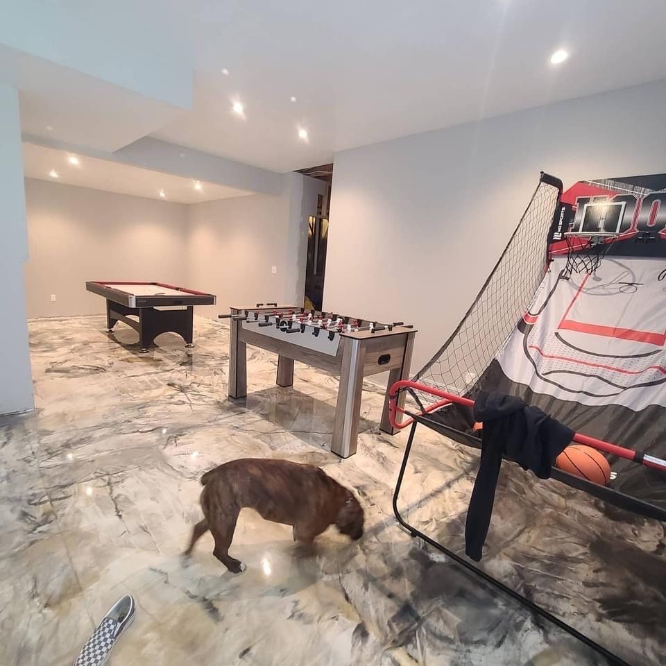 Dog sniffing a shiny floor in a rec room with a pool table, foosball, and a basketball arcade game.