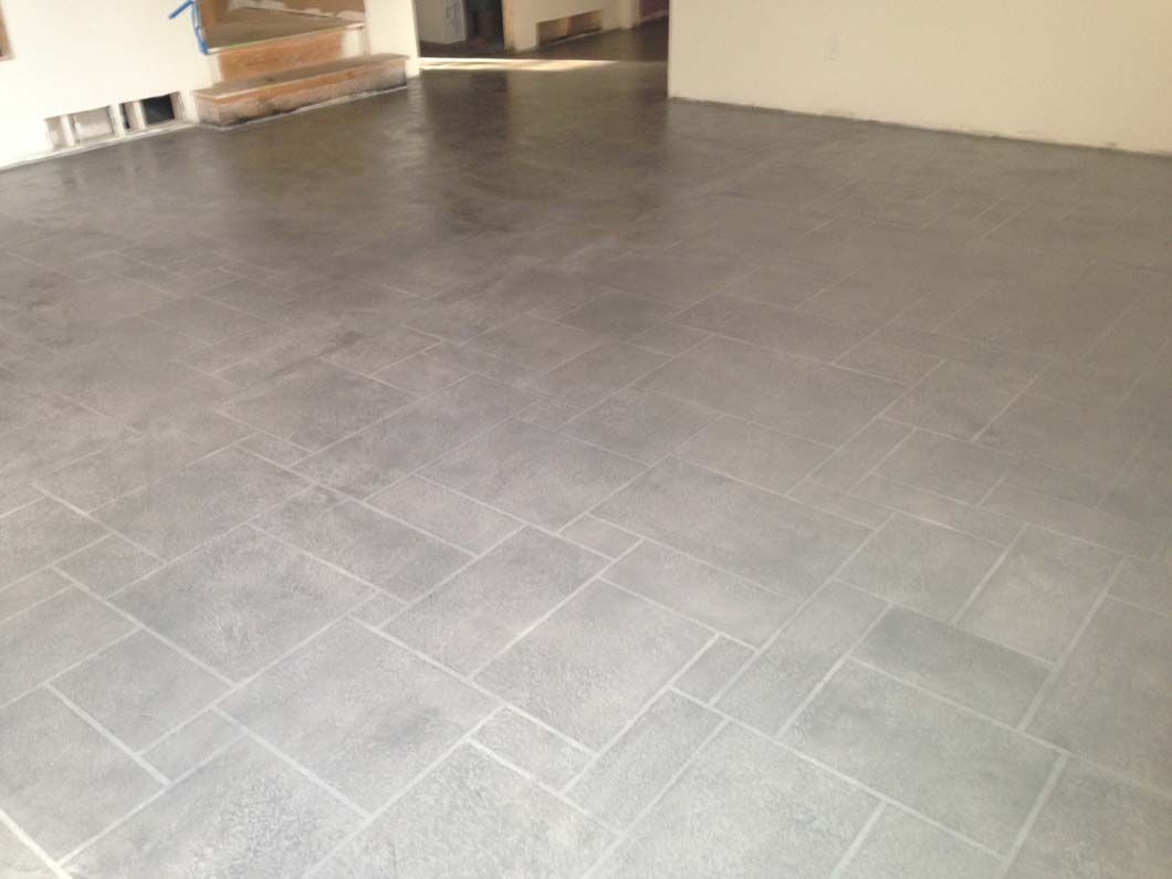 Gray tiled floor in a room; stairs visible in the background.