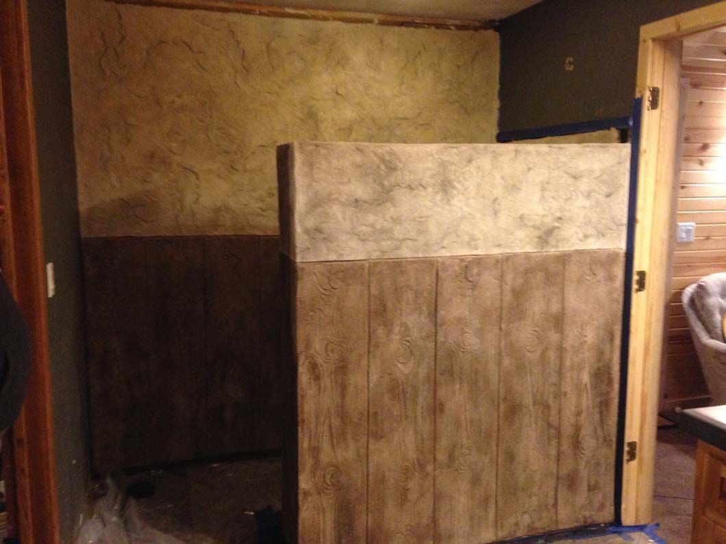 Rustic style bathroom stall with dark brown and beige textured walls and door frame.