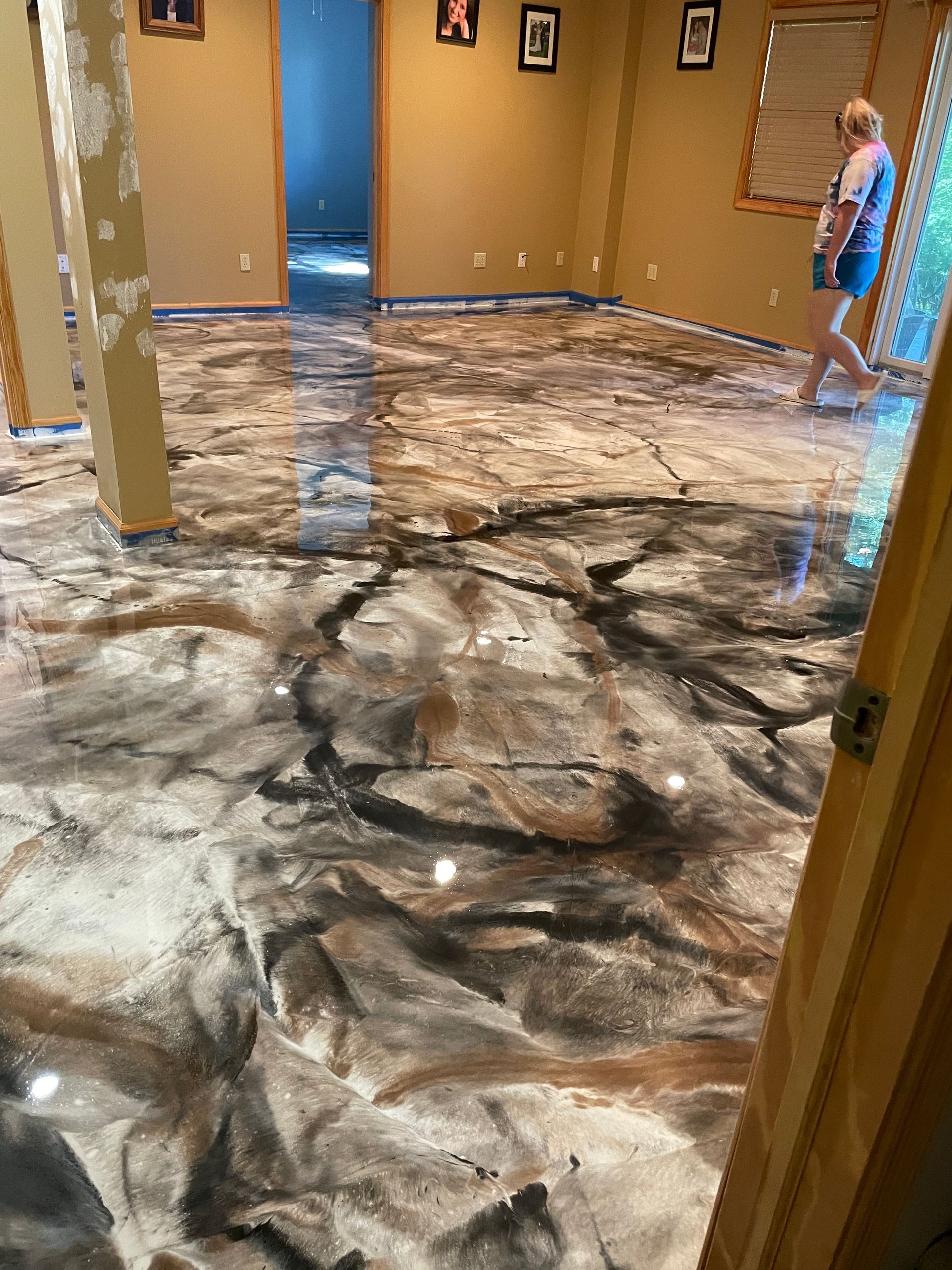 Metallic epoxy floor with black, brown, and white swirls; person walking nearby.