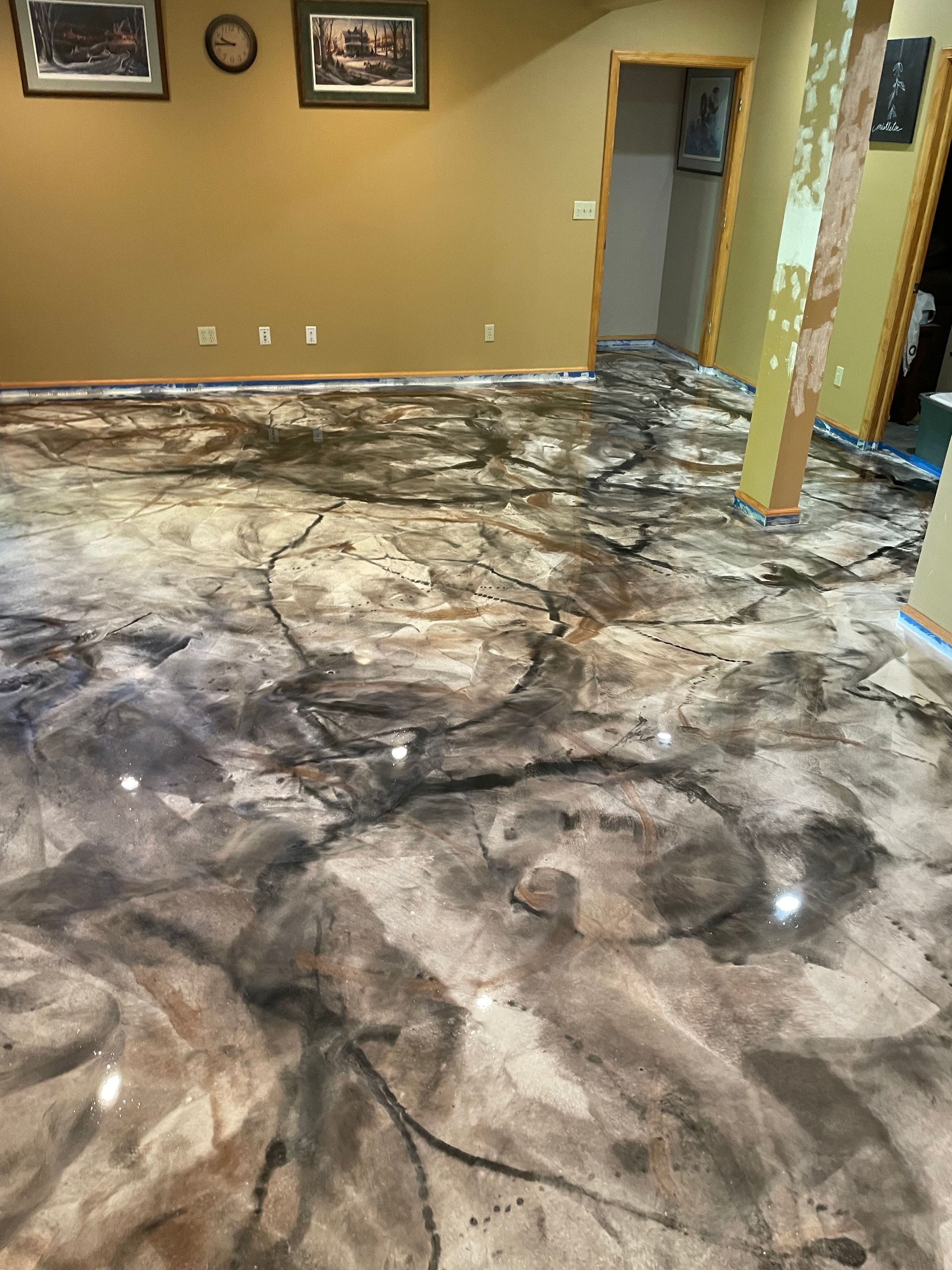 Metallic epoxy floor with dark and light swirls; room has gold walls.