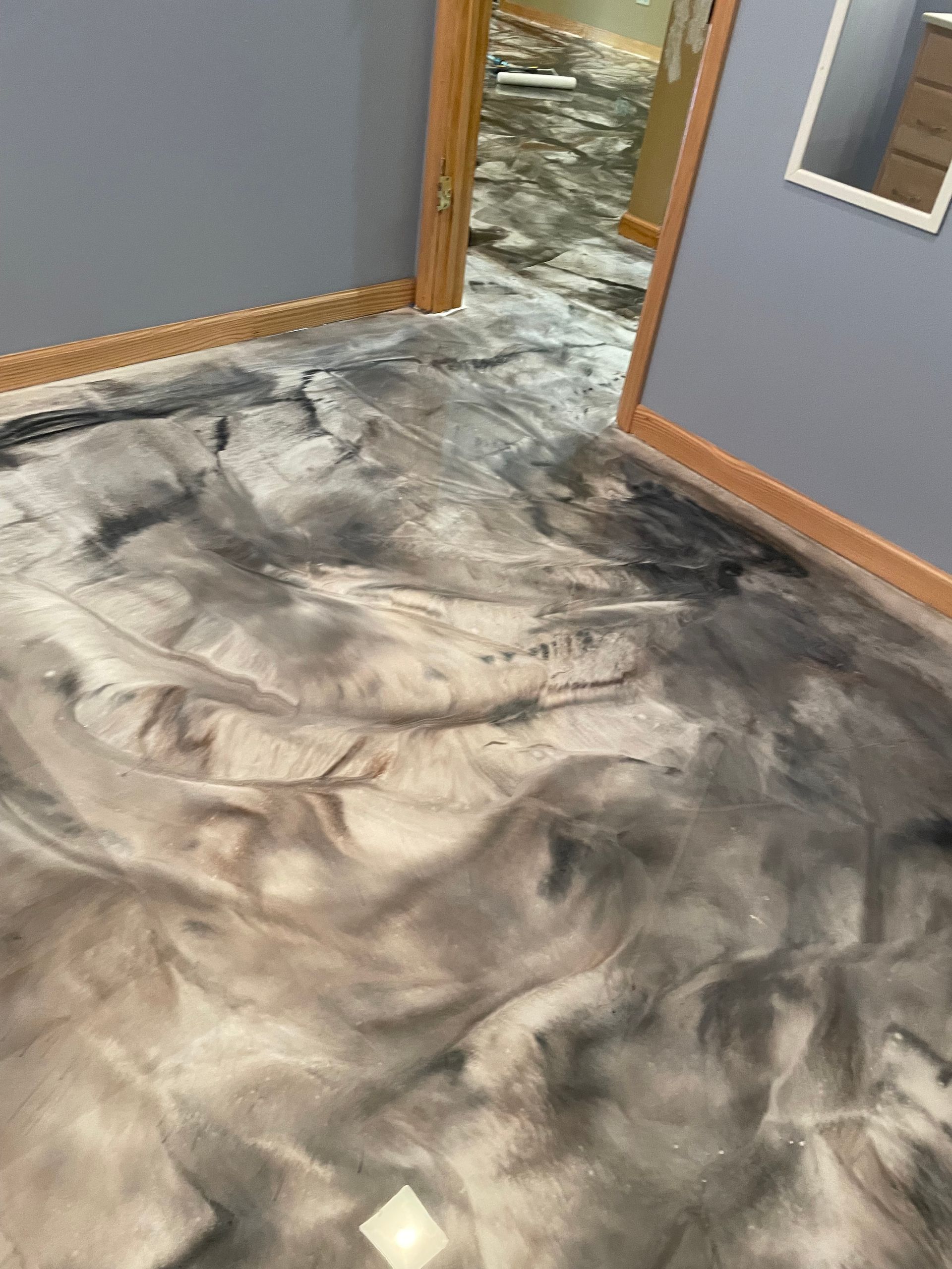 Gray and silver epoxy flooring with a marbled design in a room.