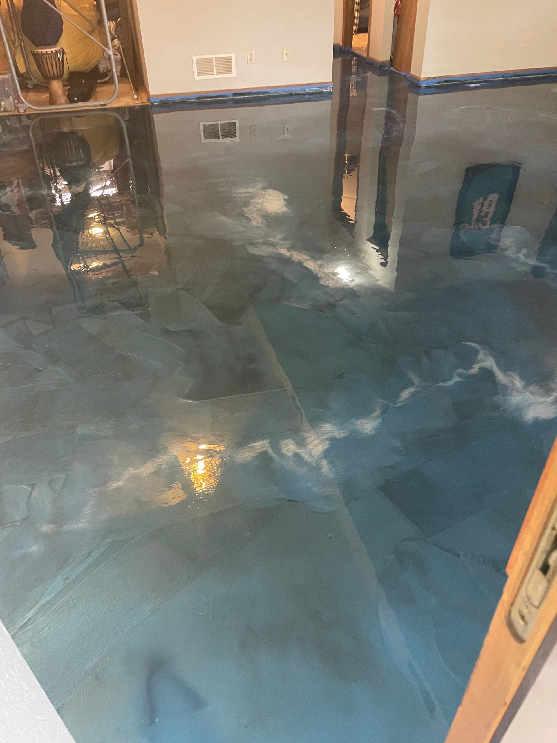 Blue metallic epoxy floor with cloud-like patterns, reflecting light.
