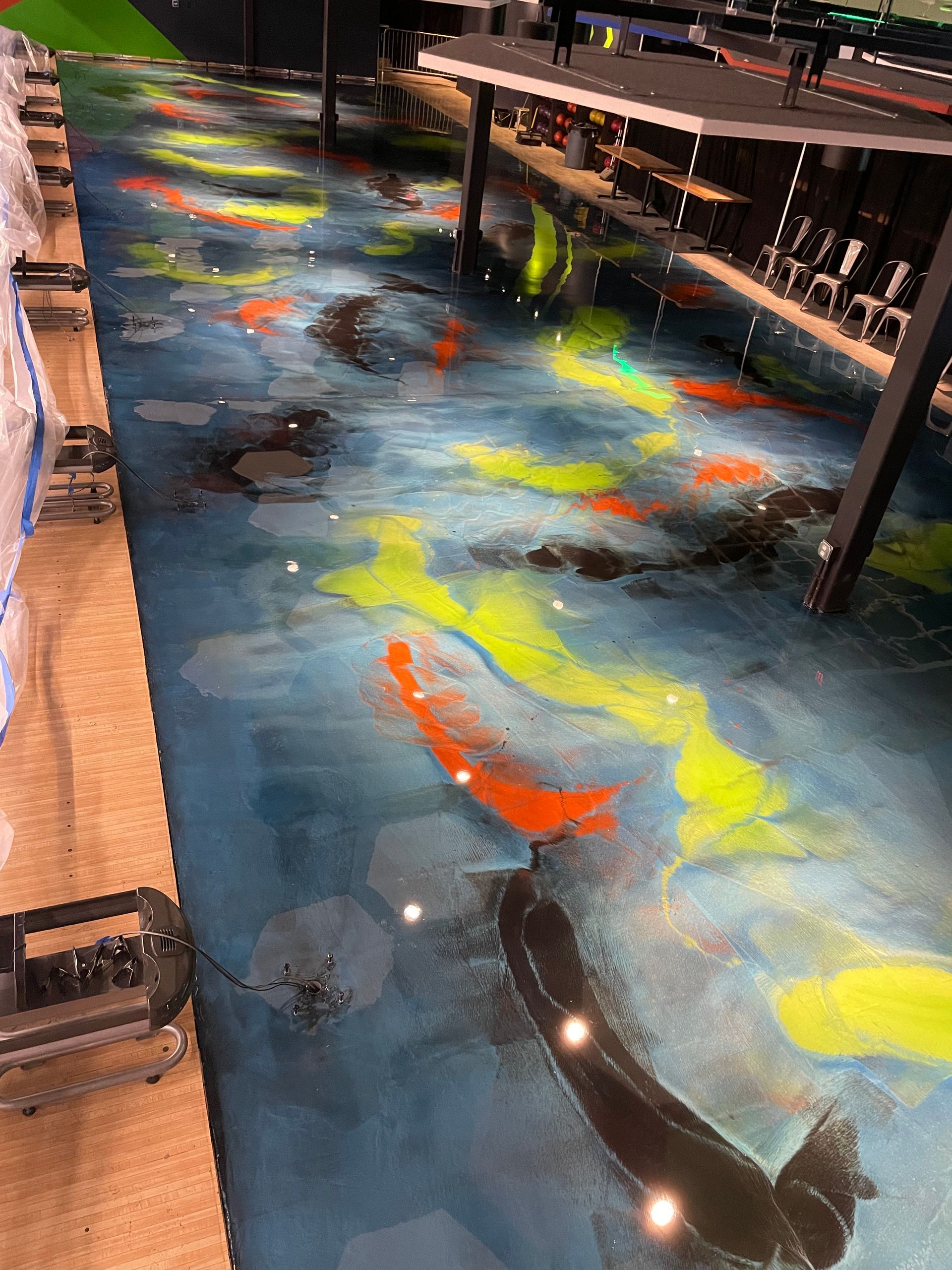 Koi fish epoxy floor with blue, orange, and yellow hues. A commercial setting.