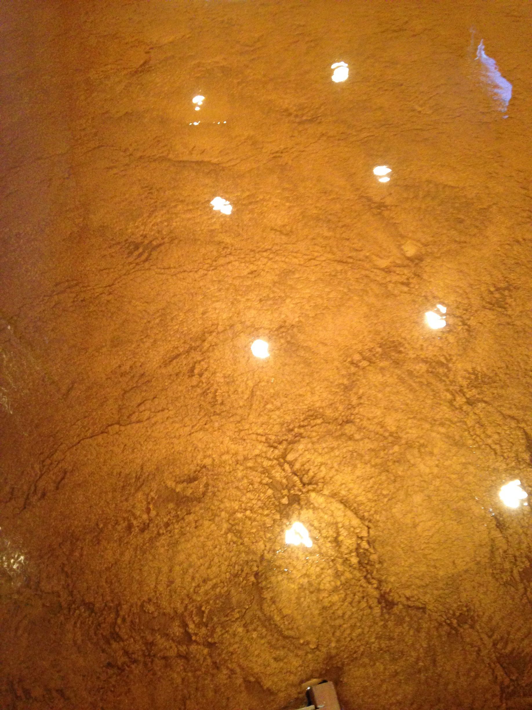 Golden-hued, textured floor with several bright light reflections.