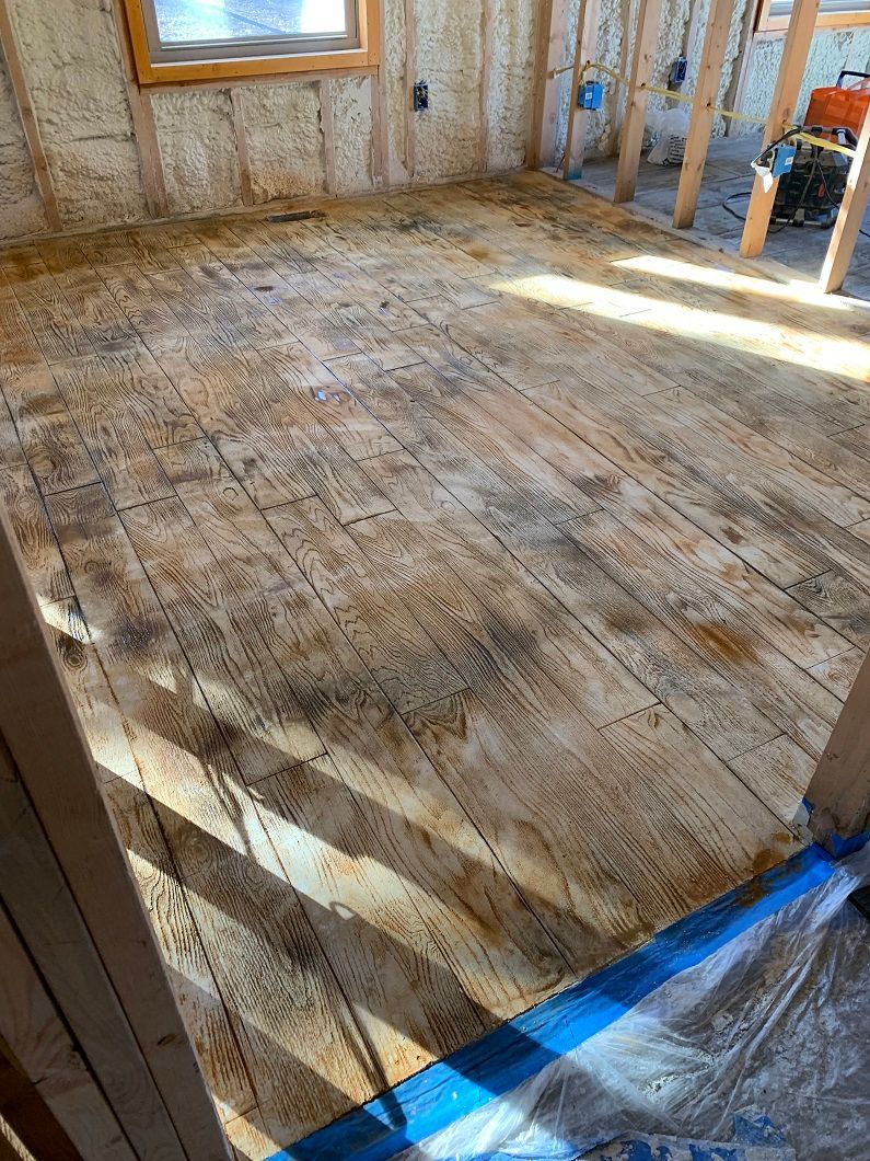 Unfinished wood floor inside a room under construction, showing stains.