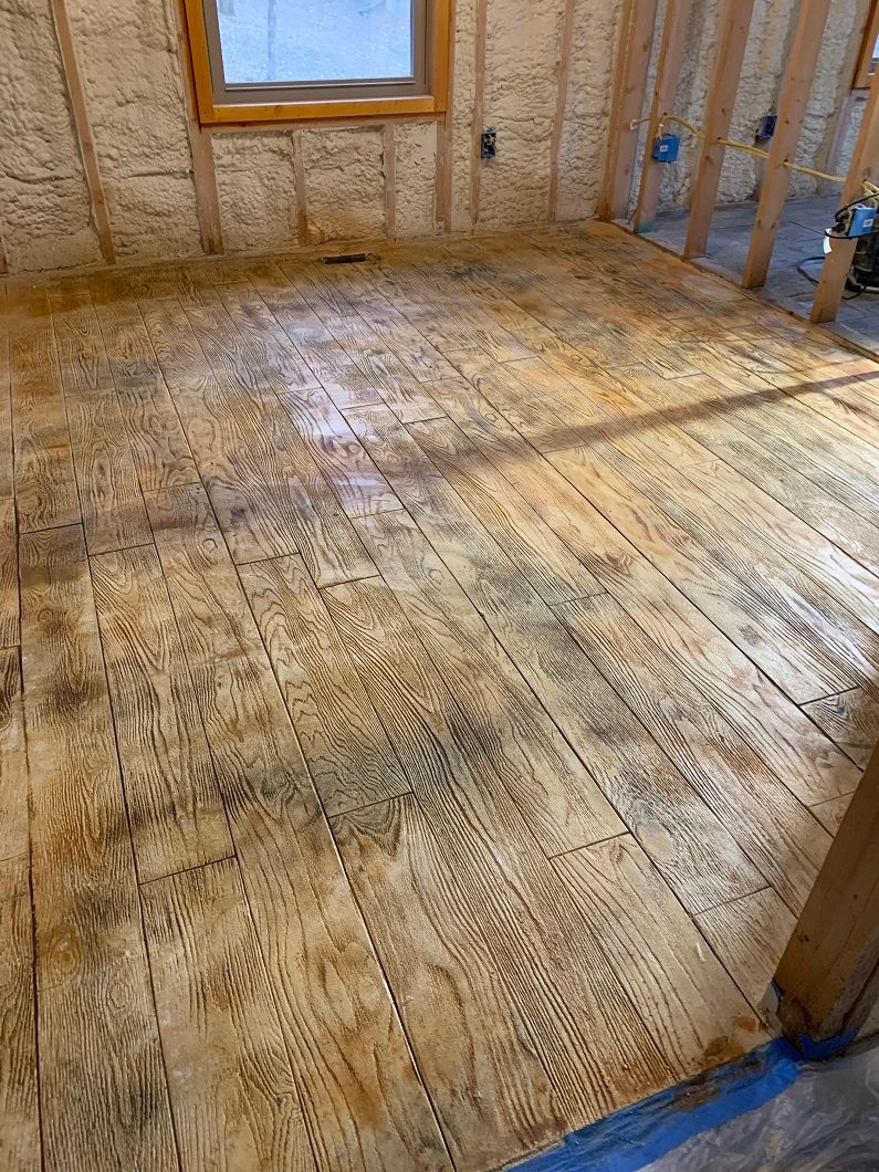 Wooden floor with dark staining in a room under construction.