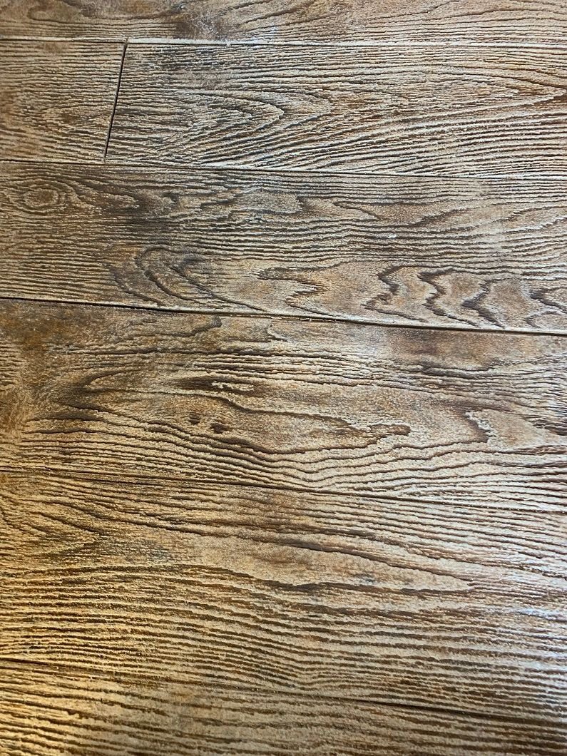 Wooden table top, light brown with visible grain and texture.