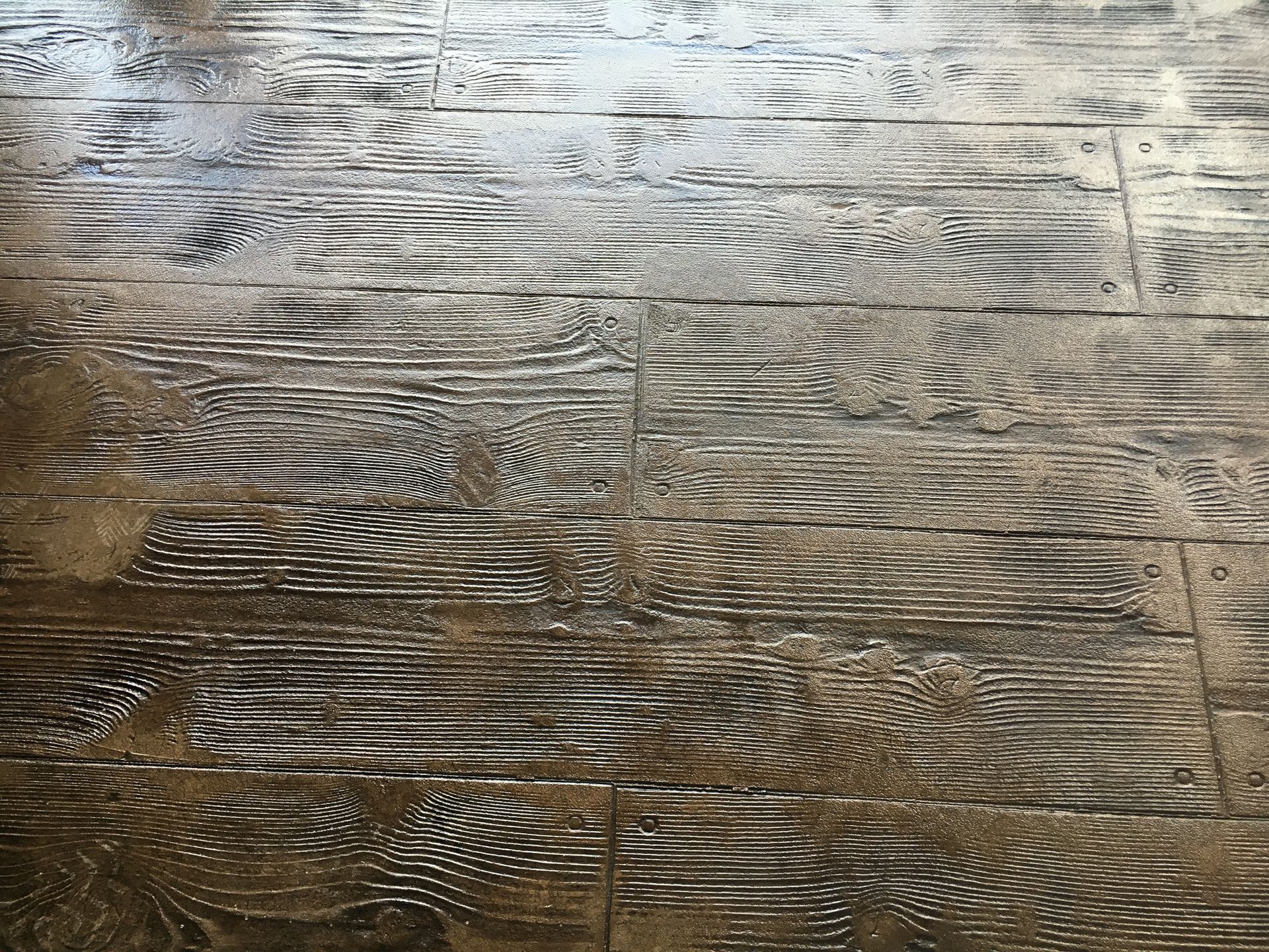 Distressed wood-look flooring in brown and white tones, with visible wood grain.