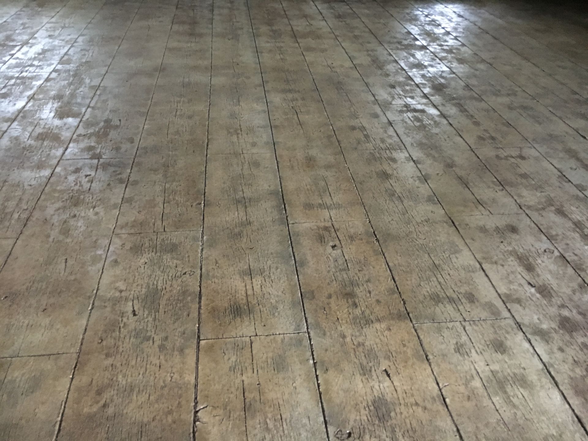 Rough, weathered wooden floorboards. Gray-brown tones, visible grain and cracks, suggesting age.