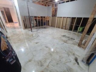 Basement with a partially flooded floor, exposed framing, and drywall in a remodel.