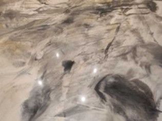 Metallic epoxy floor with swirling gray and white patterns, speckled with small embedded lights.
