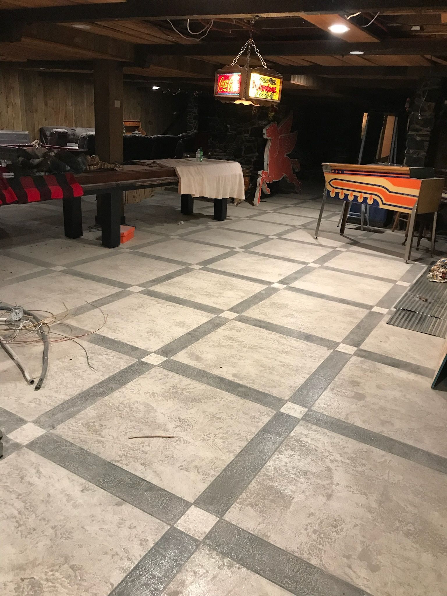 Concrete floor with a grid pattern in a dimly lit basement.