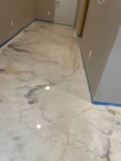Metallic epoxy floor with marble-like patterns in shades of white, gold, and gray.