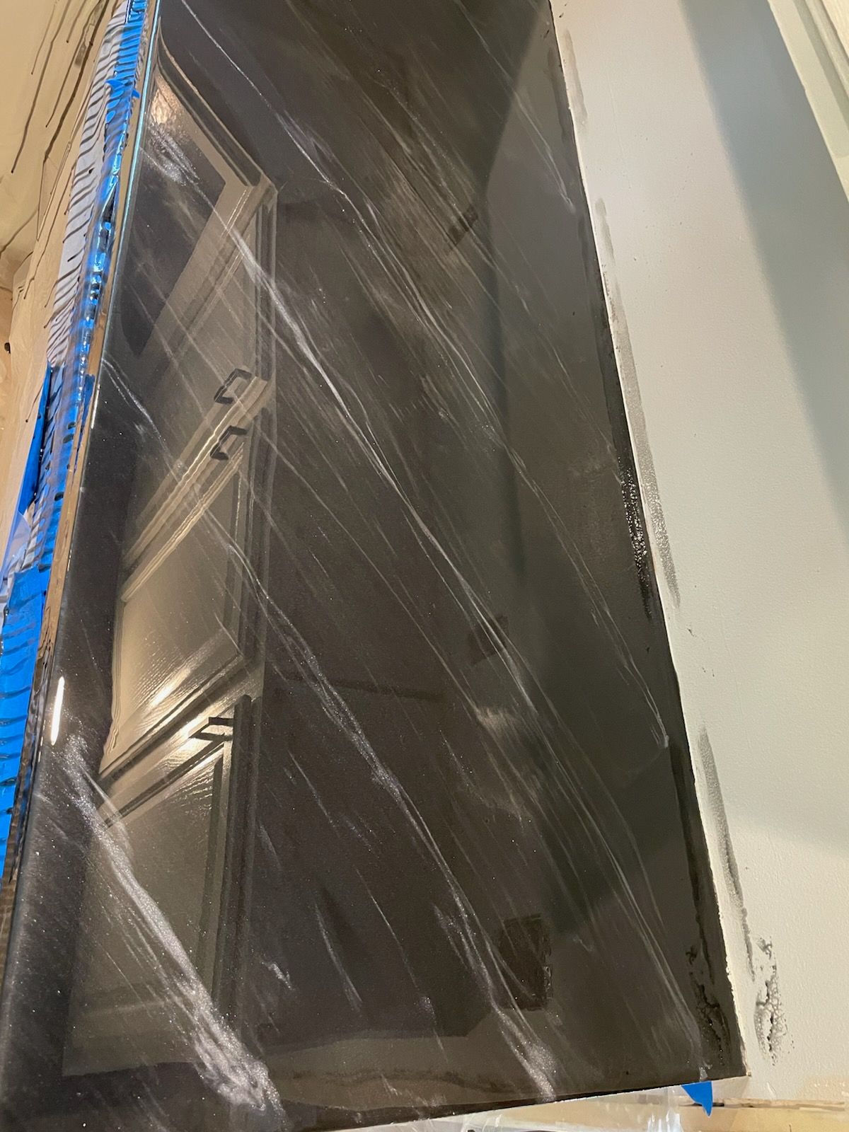 Dark countertop with white veining, covering cabinets.