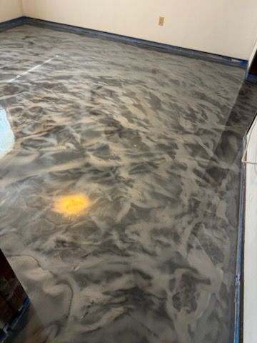 Metallic epoxy floor with silver and gray swirls in a room.