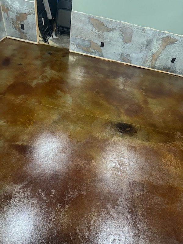 Brown and gold stained concrete floor with walls under construction.